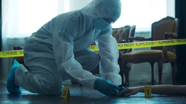 Detective Collecting Evidence in a Crime Scene. Forensic Specialists Making Expertise at Home of a Dead Person. The Concept of Homicide Investigation by Professional Police Officer.