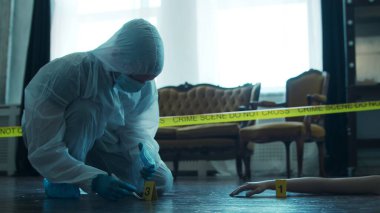 Detective Collecting Evidence in a Crime Scene. Forensic Specialists Making Expertise at Home of a Dead Person. The Concept of Homicide Investigation by Professional Police Officer.