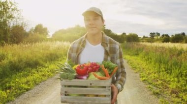 Tarım arazisinde sebze kutusu olan bir çiftçi. Kırsal kesimde bir adam. Taşra hayatı, tarım ve kırsal yaşam tarzı kavramı.