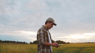 Farmer in front of a sunset agricultural landscape. Man in a countryside field. The concept of country life, food production, farming and country lifestyle.