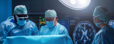 Diverse team of professional medical surgeons perform surgery in the operating room using high-tech equipment. Doctors work to save a patient in a modern hospital. The concept of medicine, technology
