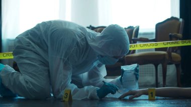 Detective Collecting Evidence in a Crime Scene. Forensic Specialists Making Expertise at Home of a Dead Person. The Concept of Homicide Investigation by Professional Police Officer.
