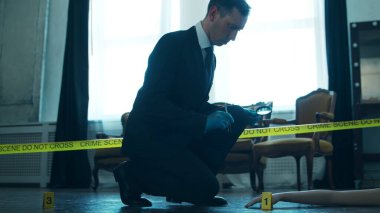 Detective Collecting Evidence in a Crime Scene. Forensic Specialists Making Expertise at Home of a Dead Person. The Concept of Homicide Investigation by Professional Police Officer.