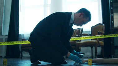 Detective Collecting Evidence in a Crime Scene. Forensic Specialists Making Expertise at Home of a Dead Person. The Concept of Homicide Investigation by Professional Police Officer.