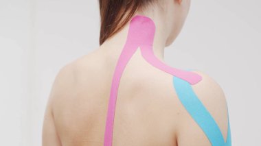 Therapist is applying tape to beautiful female body. Physiotherapy, kinesiology and recovery treatment.
