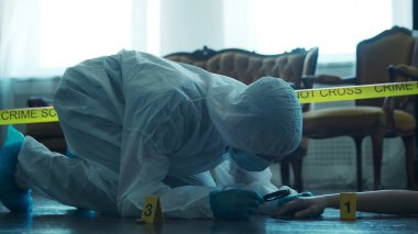 Detective Collecting Evidence in a Crime Scene. Forensic Specialists Making Expertise at Home of a Dead Person. The Concept of Homicide Investigation by Professional Police Officer.