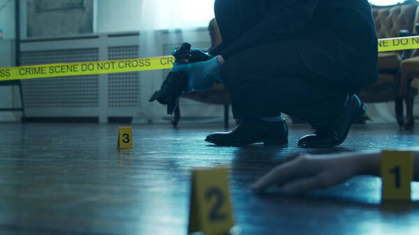 Detective Collecting Evidence in a Crime Scene. Forensic Specialists Making Expertise at Home of a Dead Person. The Concept of Homicide Investigation by Professional Police Officer.