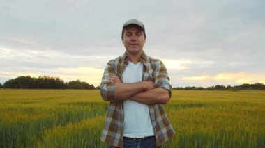 Günbatımı tarımının önündeki çiftçi. Kırsal kesimde bir adam. Kır hayatı, gıda üretimi, tarım ve kırsal yaşam tarzı kavramı.