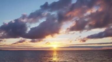 Timelapse with Sunset and Cumulus Clouds Flying High in a Beautiful Blue Sky. Sun Dawn in the Sea. Concept of Weather, Climate Change and Global Warming.