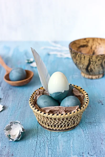 Still life with blue easter eggs in a wattled plate — Stock Photo, Image