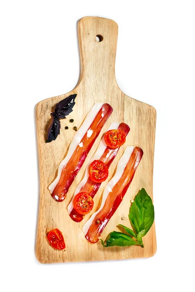 Strisce di pancetta, pomodori secchi, foglie di basilico fresche servite su — Foto Stock