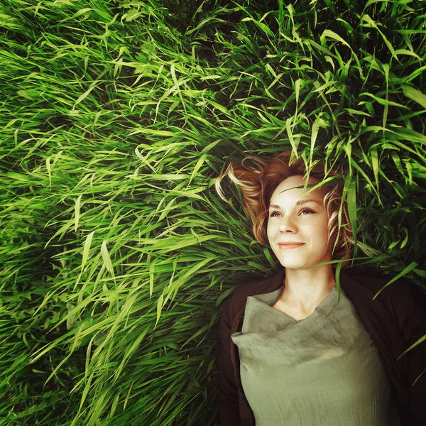 Çimlere yatan güzel bir genç kadın. instagram retro etkisi — Stok fotoğraf