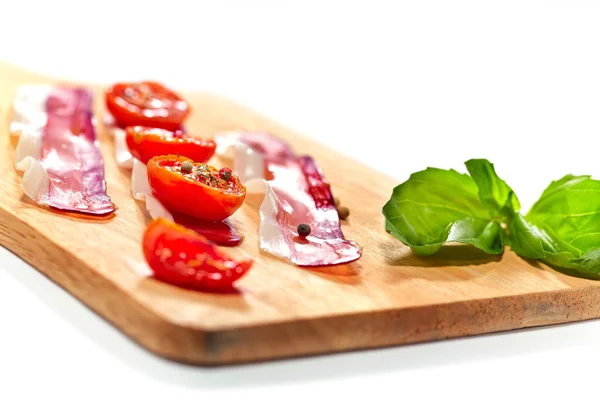 Light snack. Dried tomatoes and bacon served on board. Selective — Stock Photo, Image