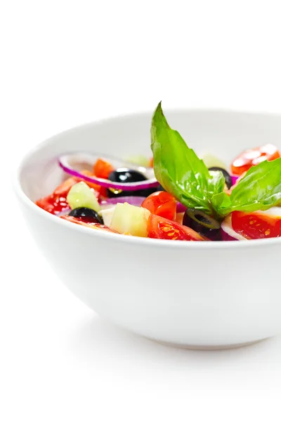 Griekse salade met groenten, gegarneerd met basilicum. geïsoleerd op w — Stockfoto