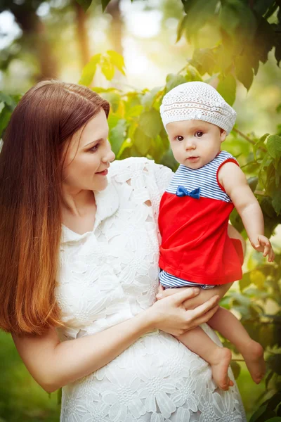 Beautiful young mother and daughter in summer park — Stock Photo, Image