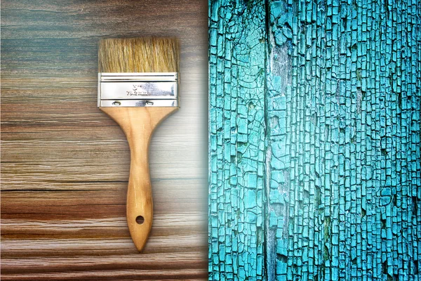 Renovation brush on wooden blue cracked texture — Stock Photo, Image