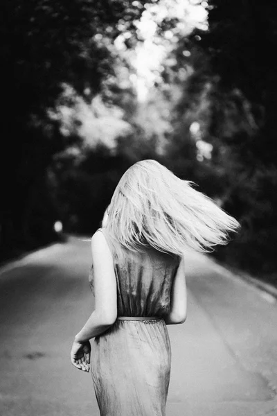 Blonde girl dancing on the road. Black and white. — Stock Photo, Image