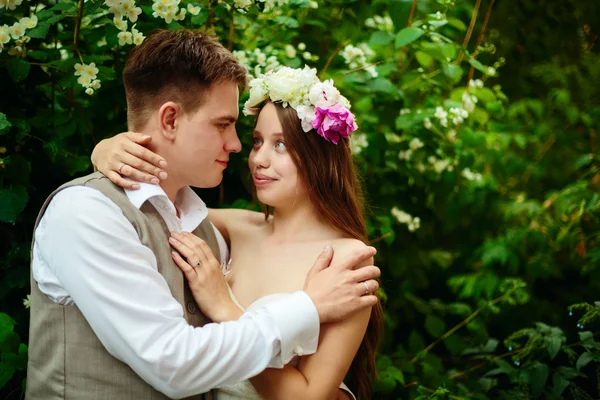 Verheugd huwelijksfeest paar in bloemen — Stockfoto