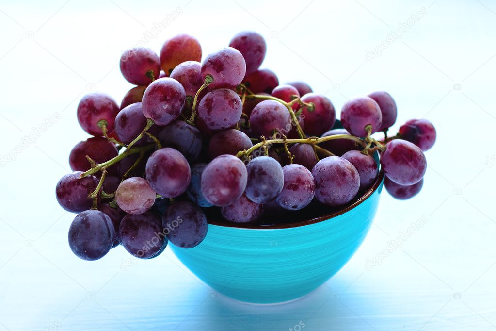 Bunch of blue grapes on blue background