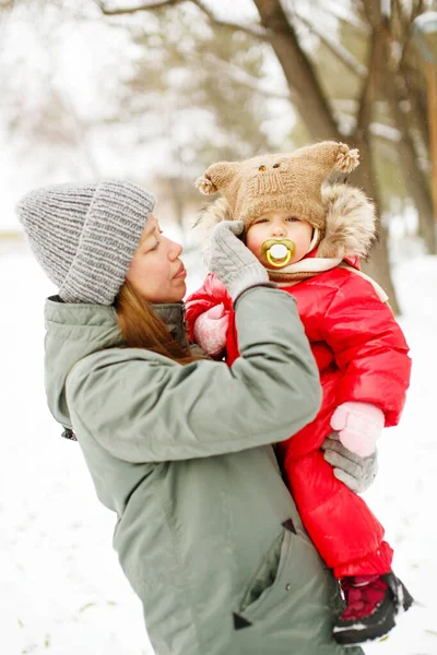 Junge Frau Winterlichen Freizeitoutfit Spaziert Mit Ihrem Kleinkind Verschneiten Park lizenzfreie Stockfotos