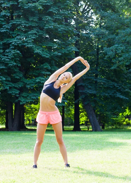 The beautiful blonde stretching outdoors — Stock Photo, Image