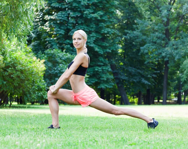 The beautiful blonde stretching outdoors — Stock Photo, Image