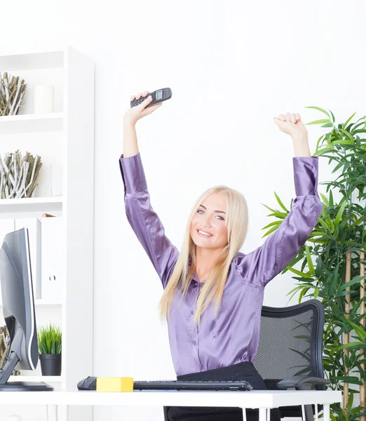 Successful young blonde businesswoman, victory gesture, hands up, smiling at office — Stock Photo, Image
