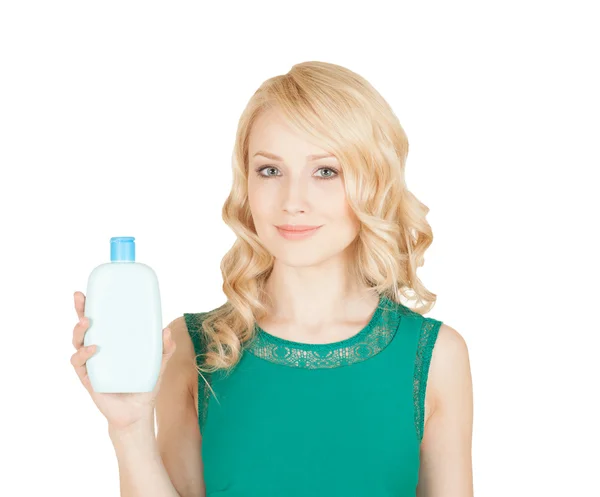 Hermosa rubia sostiene en una mano una botella de cosméticos —  Fotos de Stock