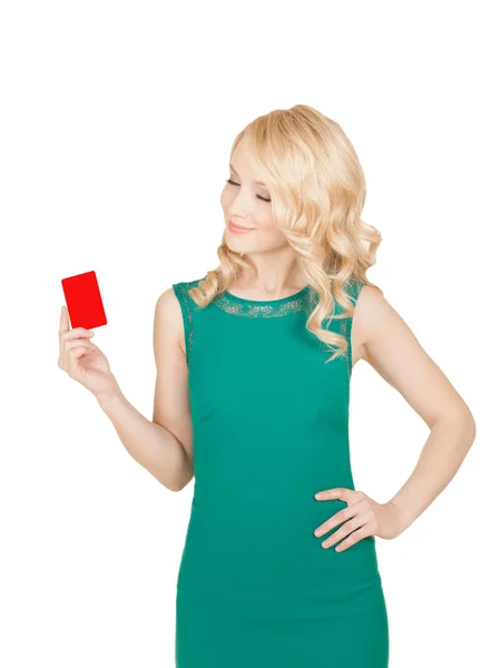 Beautiful blonde in a green dress holds a card — Stock Photo, Image