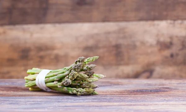 Bunches of asparagus tied on a wood background. — Zdjęcie stockowe