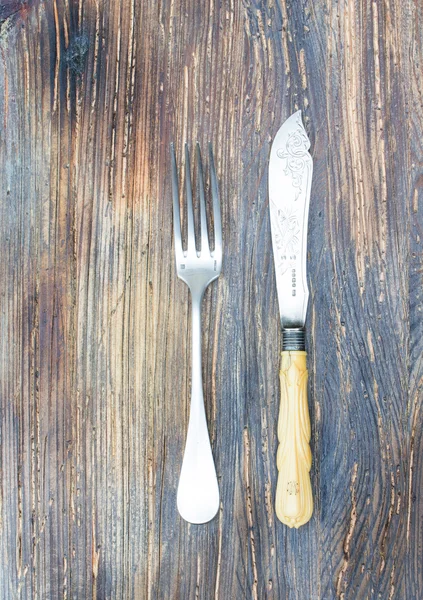 Vintage a knife a fork on a wooden board — Stock Photo, Image