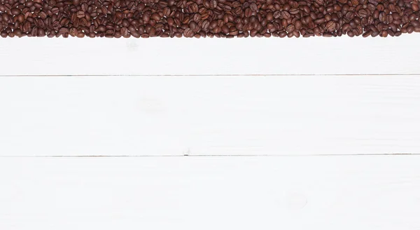 Fundo prancha de madeira branca com grãos de café — Fotografia de Stock