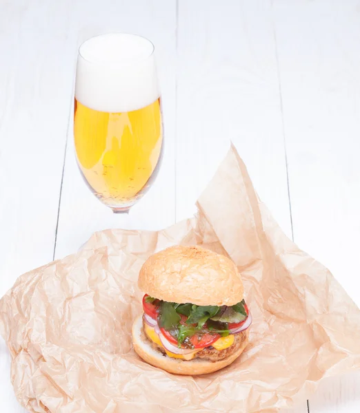 Hamburger kaas uien saus tomaten op papier en bier — Stockfoto