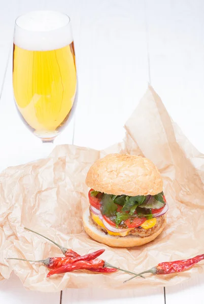 Hamburger kaas uien saus tomaten op papier en bier — Stockfoto