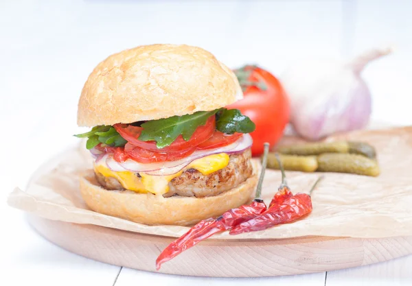 Hamburger cheese onions sauce tomatoes on paper — Stock Photo, Image