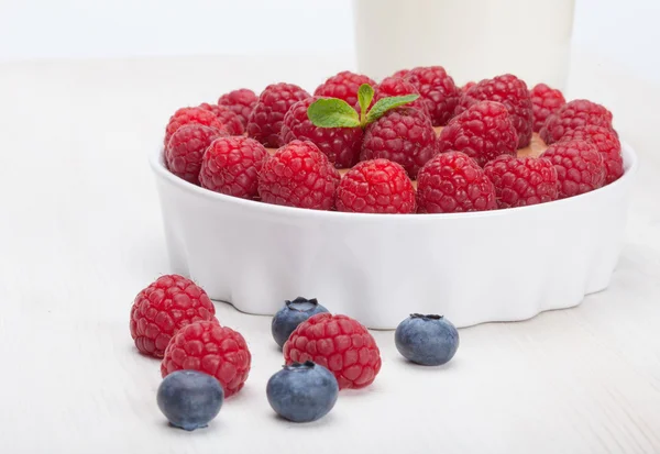 Raspberry bilberry in white bowls and milk — Stock Photo, Image