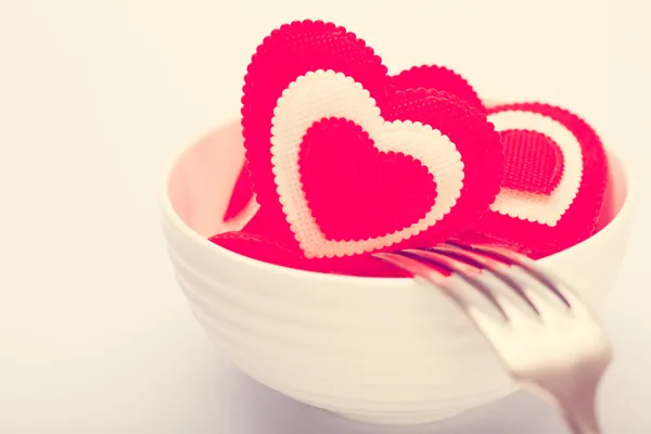 Hearts in a white bowl with a fork. Toned in warm colors — Stock Photo, Image