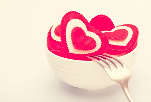 Hearts in a white bowl with a fork. Toned in warm colors — Stock Photo, Image
