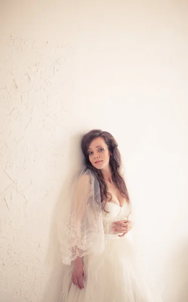 La novia hermosa en un vestido blanco fino. se tonifica en colores cálidos —  Fotos de Stock