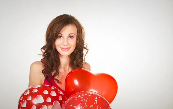 Vacker brunett i en röd klänning med ballonger — Stockfoto
