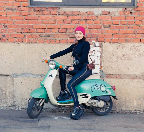 La chica en el negro se sienta en el scooter verde vintage con vintage la cámara — Foto de Stock