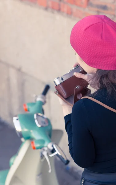 A menina fotografa a scooter verde vintage a câmera vintage — Fotografia de Stock