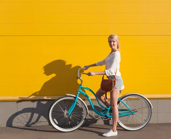 Young sexy blonde girl is standing near the vintage green bicycle with brown vintage bag — Stock Photo, Image