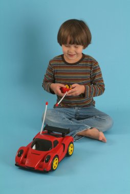 Uzaktan kumandalı oyuncak bir arabayla oynayan çocuk