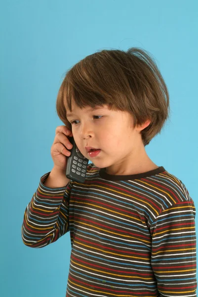 Barn talar med en mobiltelefon — Stockfoto