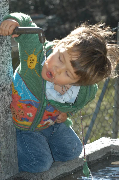 Young boy drinking water — Stock Photo, Image