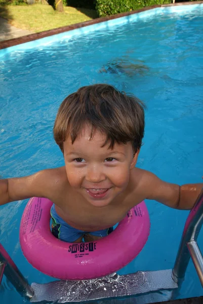 Niño tomando el sol en la piscina — Foto de Stock