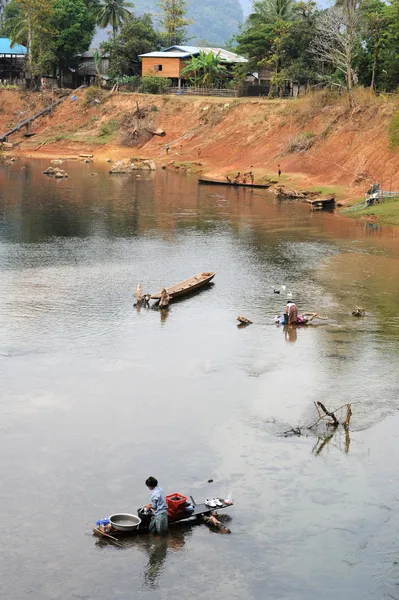 Myje ubrania przez rzeki na laos — Zdjęcie stockowe