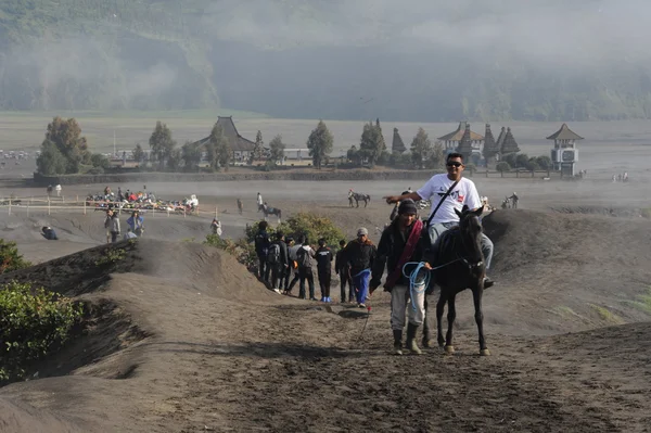 游客对马攀爬的装载溴火山斜坡 — 图库照片