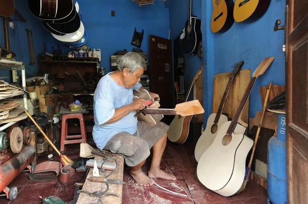Man die gitaar in zijn winkel — Stockfoto
